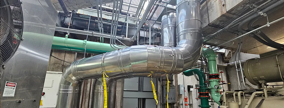 Common flue routing through the penthouse, cored through the ceiling/roof and navigated around existing equipment and electrical panels.