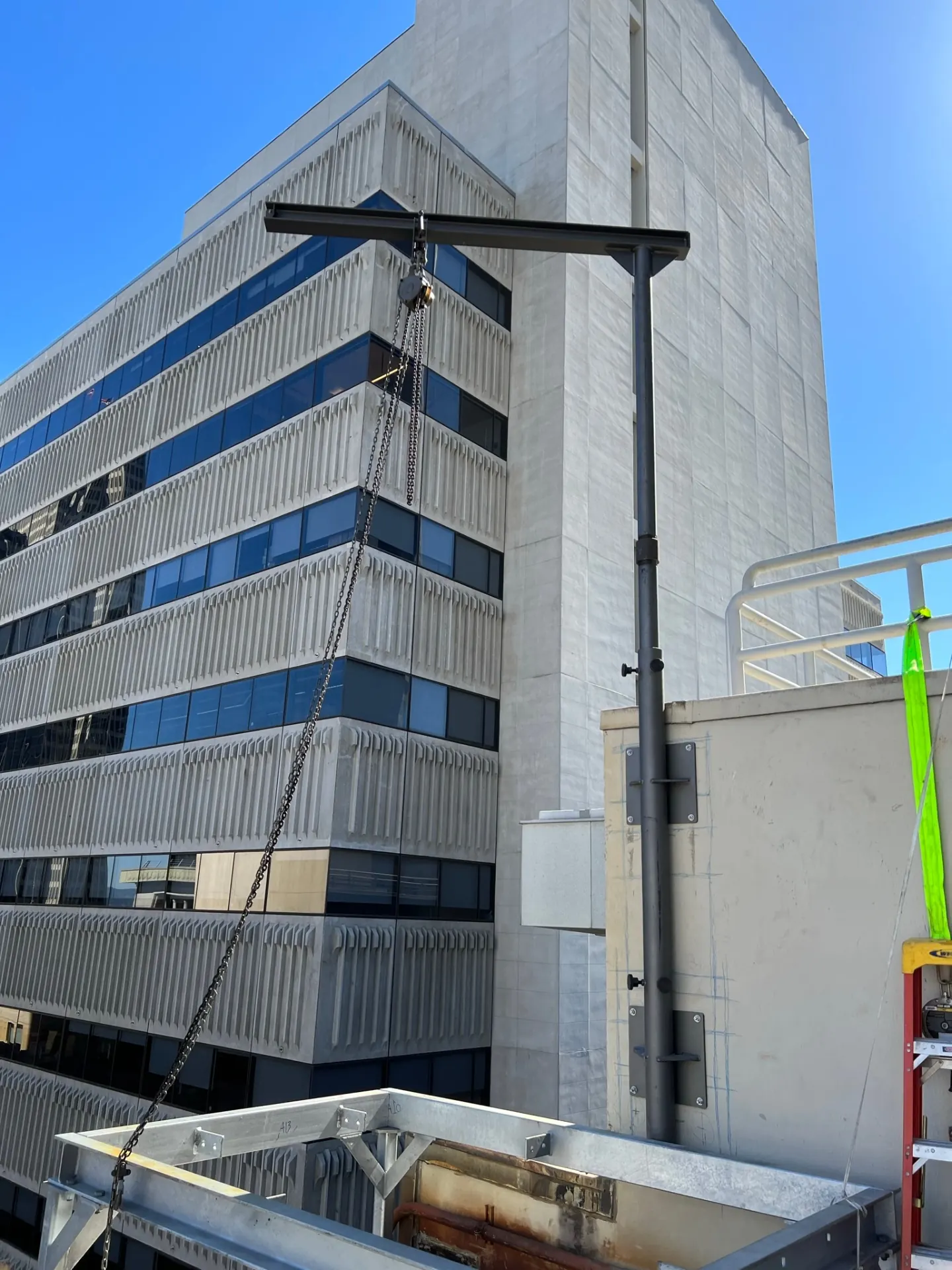 Guy-wire rigging from the davit arm anchored to the building structure.