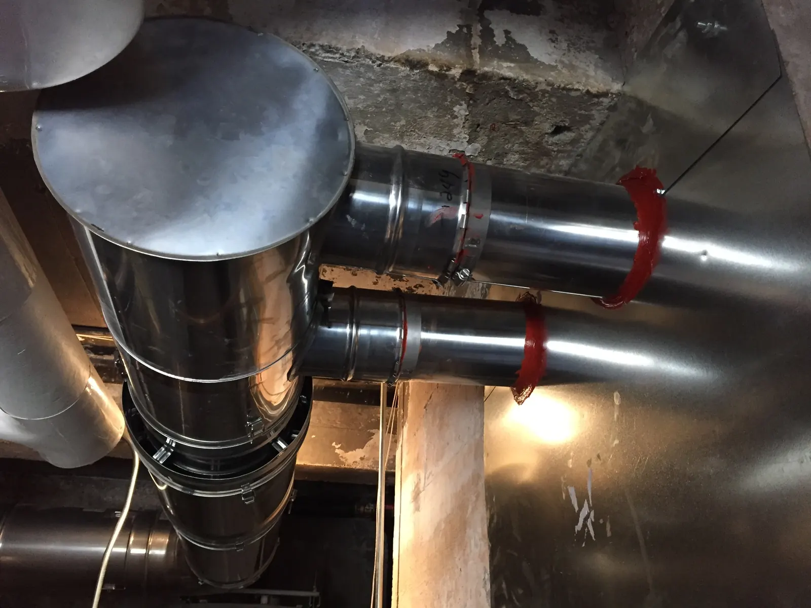 Two liners extending from the header into the two chambers of the masonry chimney.