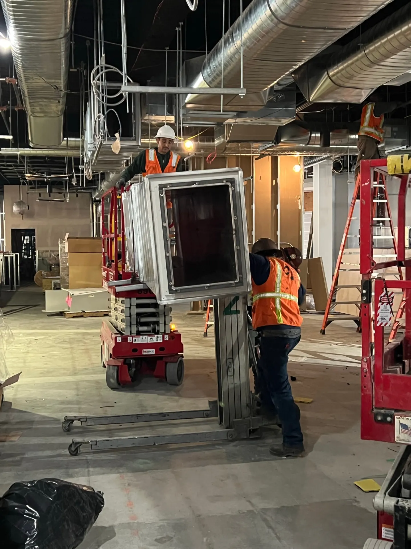 Factory-built sections lifted into place on a scissor lift during install.